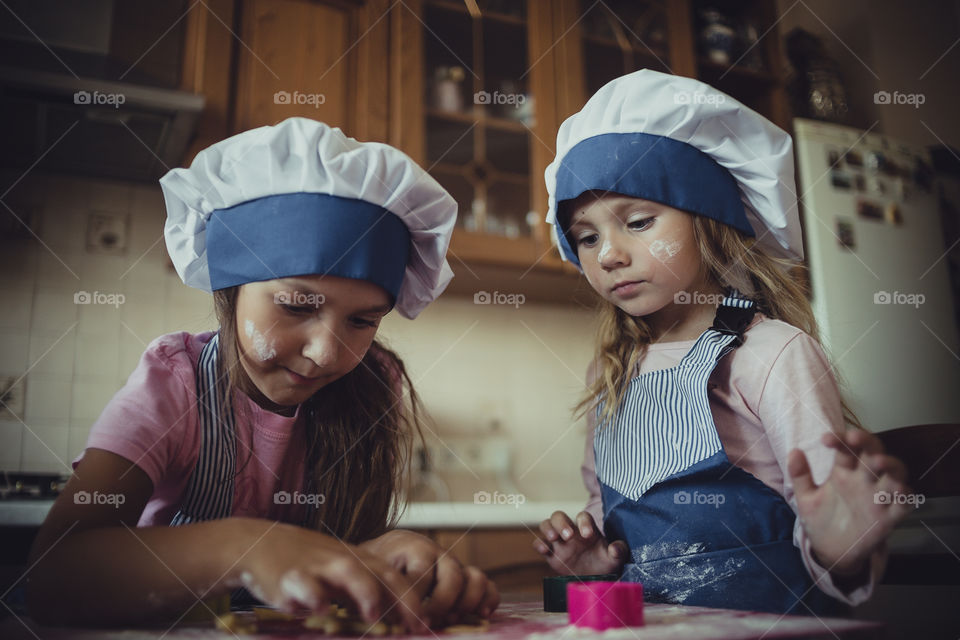 Little sisters cooking the biscuits 