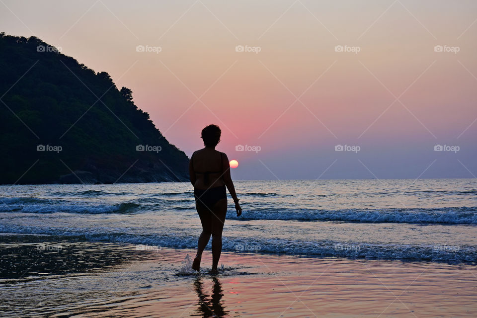 woman in the beach during a sunset