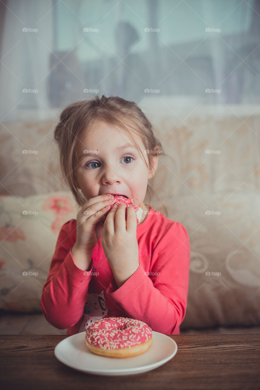 Little girl eating donuts 