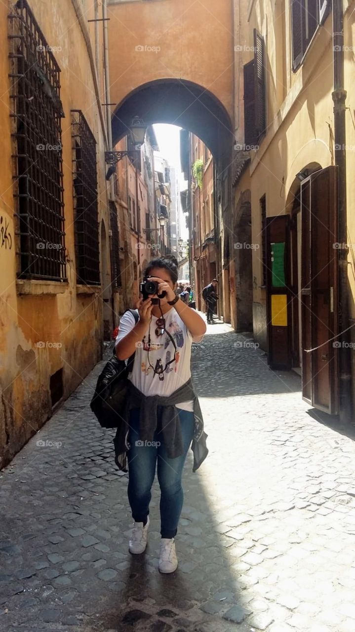 Girl taking a photo of something beautiful in Rome