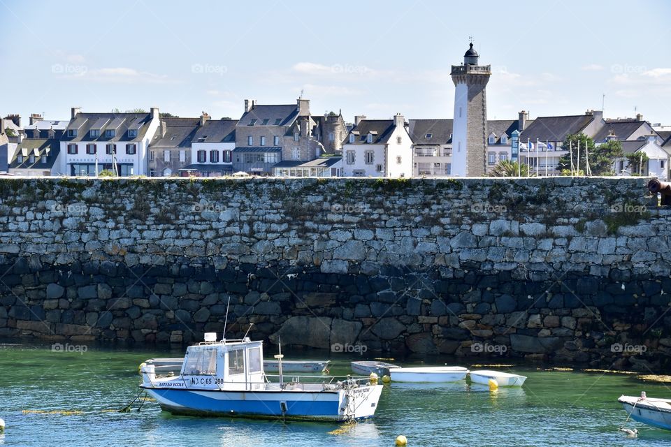 A boat in the Harbour of Roscoff with Lighttower 