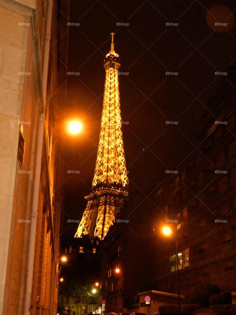 Eiffel Tower from a distance. A view of the Eiffel Tower from a side street between buildings.