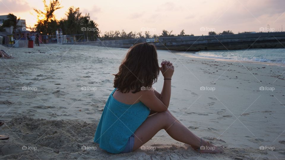 Girl thinking in the beautiful Cable beach, Nassau, Bahamas