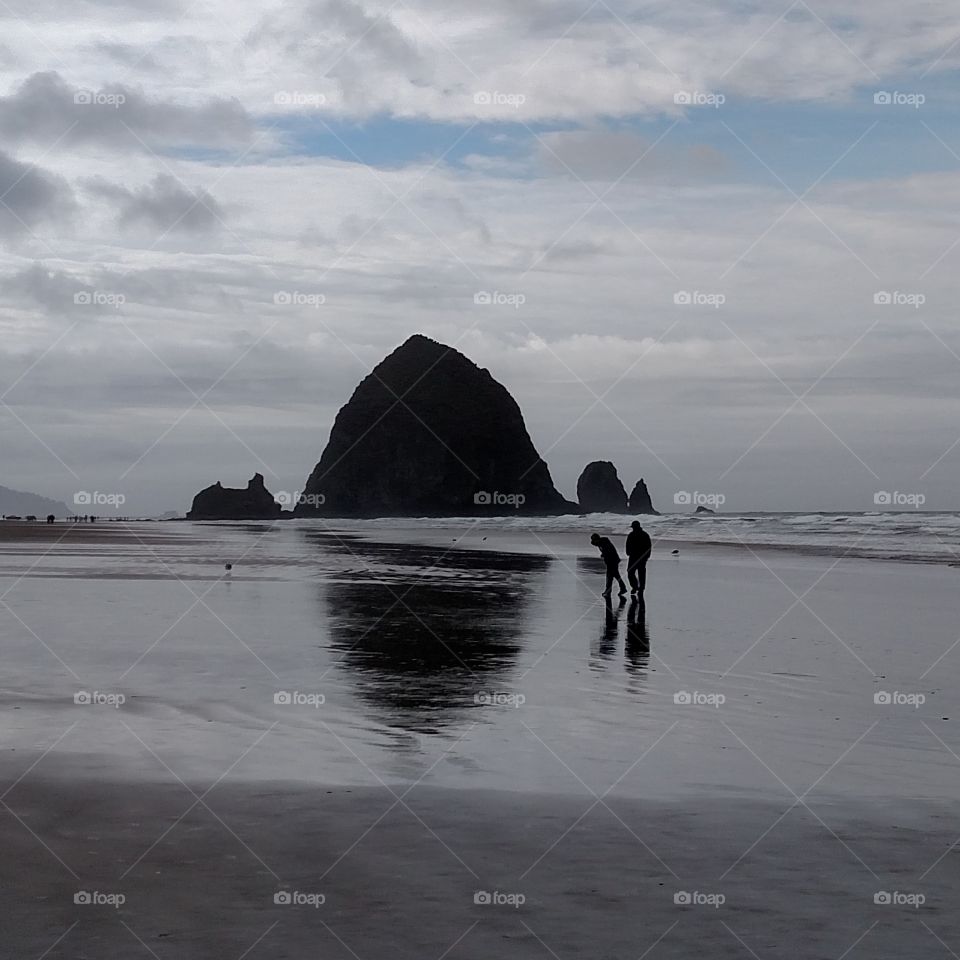 Father and son walking on the beach in Oregon