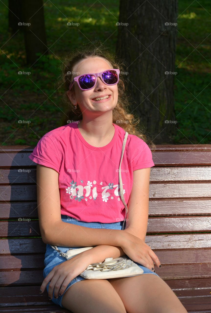 girl resting on a bench in park spring and summer time social distance