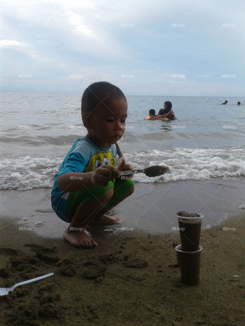 little boy in the beach
playing sand