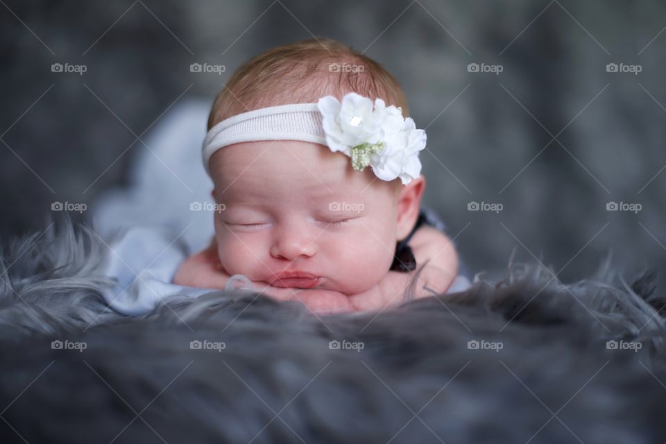 Newborn baby girl posing on a fur blanket 