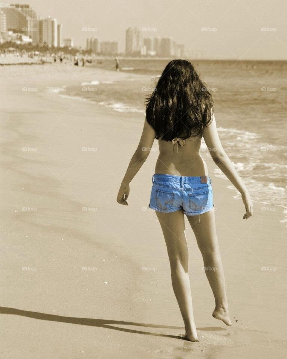 Walk on the beach. Playful walk on the beach in blue jeans 