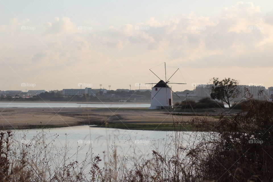 Windmill in small island in the middle of a river 