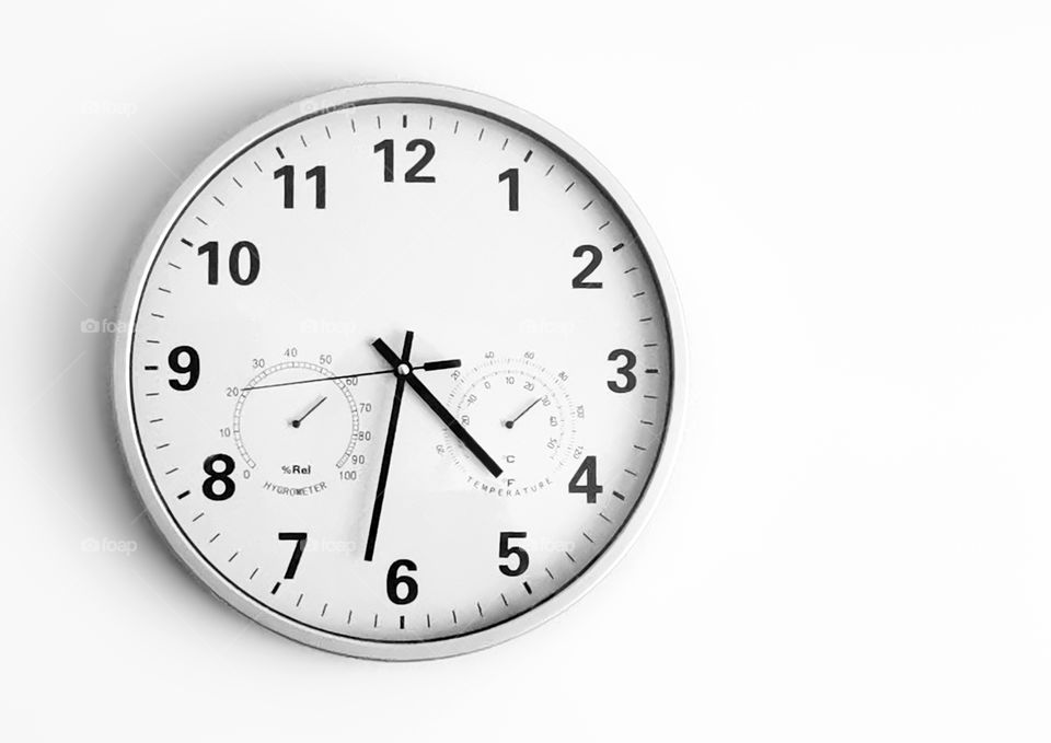 Black and white photo of Time, Temperature, and Humidity Wall Clock on white blurred background with copy space. Concept of time study in any language.