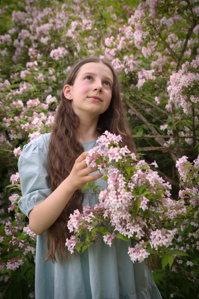 Young girl with long hair with blooming tree