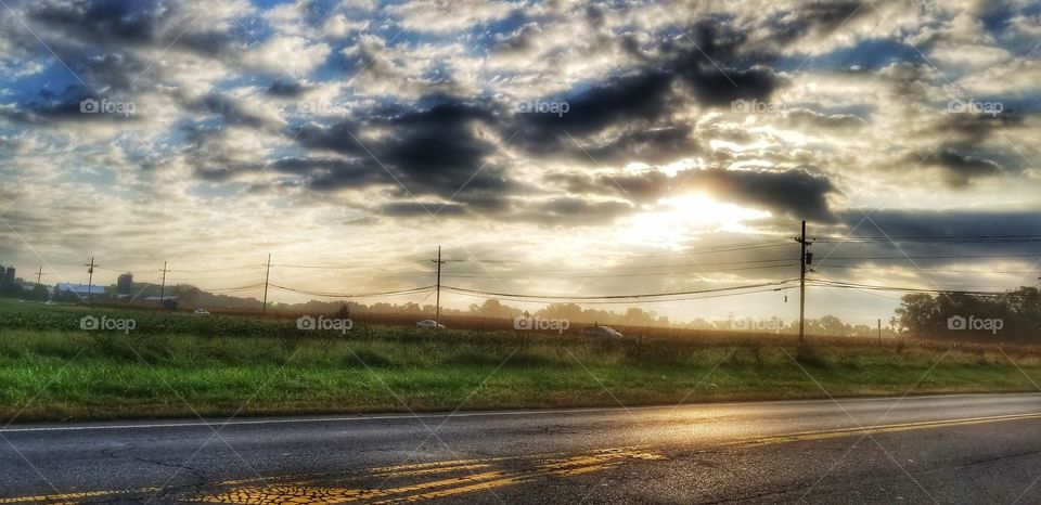 Sun and clouds over a field