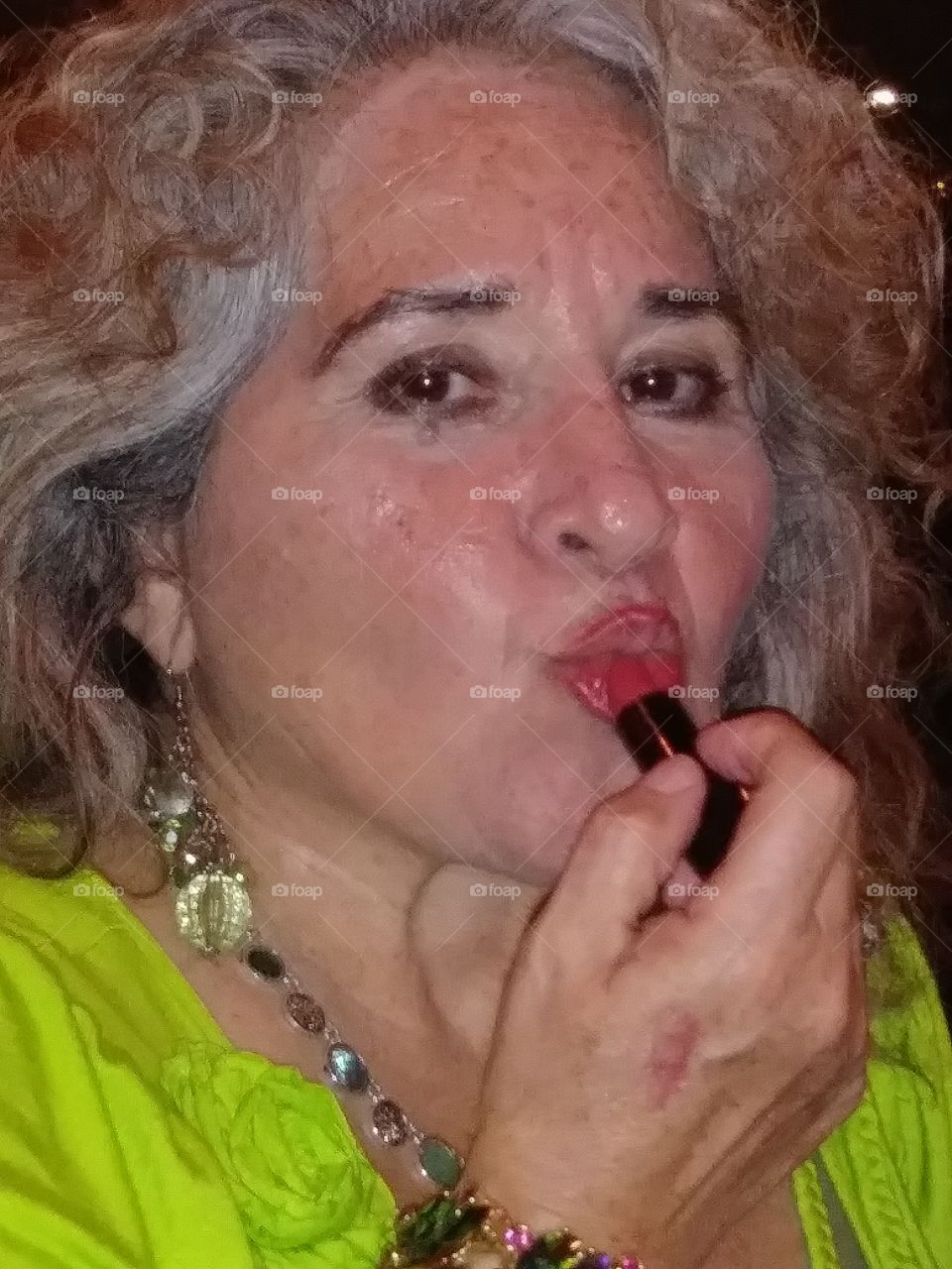 older lady applying lipstic, feeling beautiful