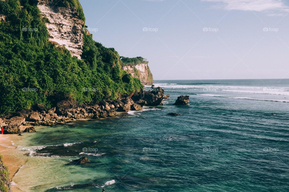 turquoise bleue océan waters along jungle covered cliffside