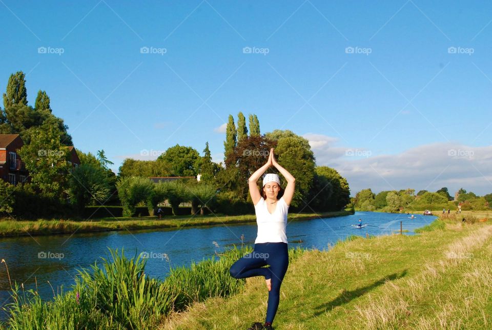 woman doing yoga by the river