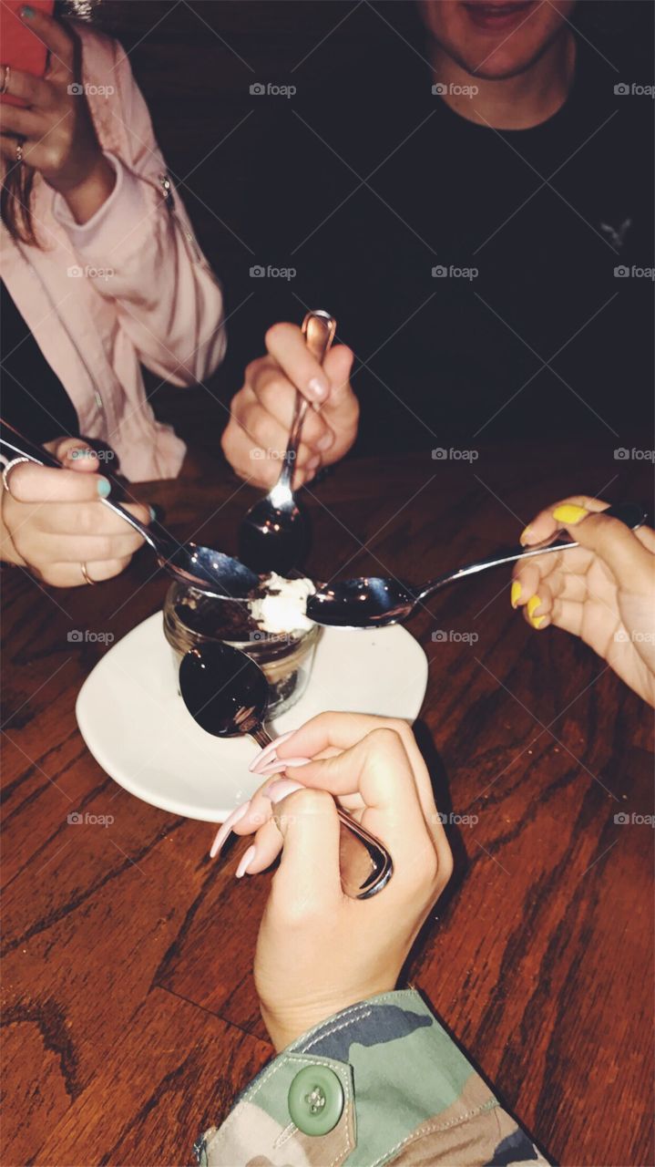 4 friends sharing a dessert at a restaurant 