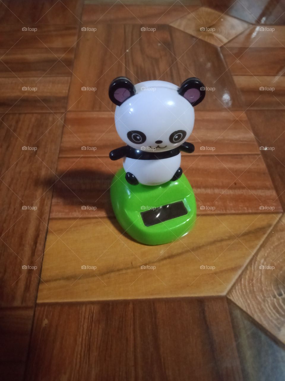 A panda toy is standing on the floor