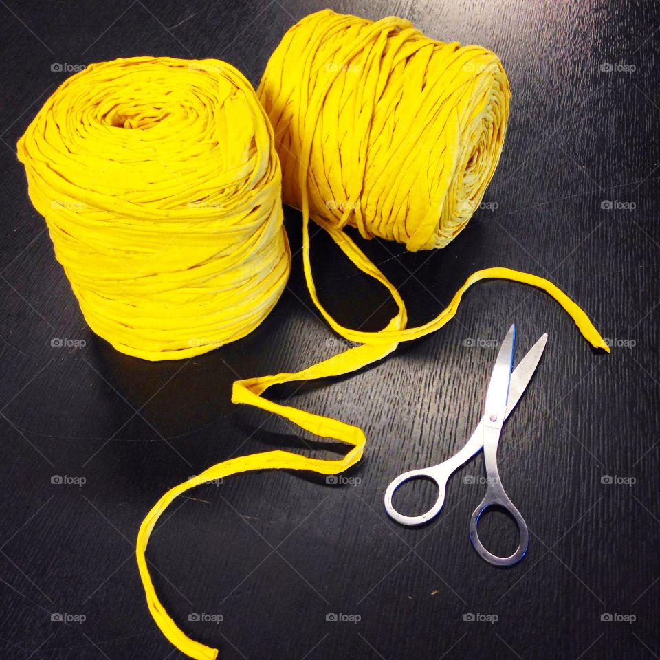 Yarn and scissors. Yellow yarn for decoration