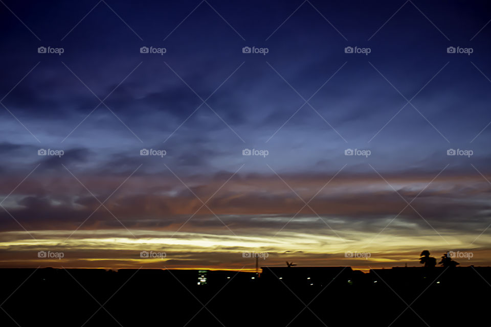 Beautiful light of Sunset with clouds in the sky reflection behind the building.