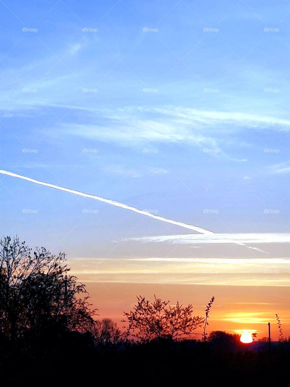 sunrise with blue sky and condensation trace