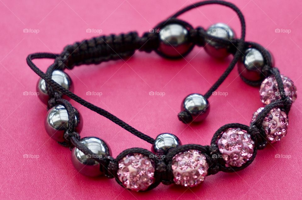 Handmade bracelet on pink background