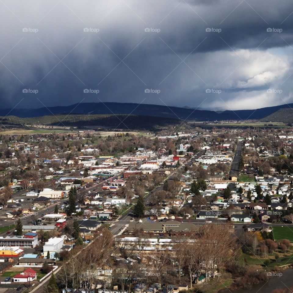 View from the Ochoco State Scenic Viewpoint of the town of Prineville, home of a growing technology sector, in Central Oregon with an intense sky from a rainstorm passing through. 