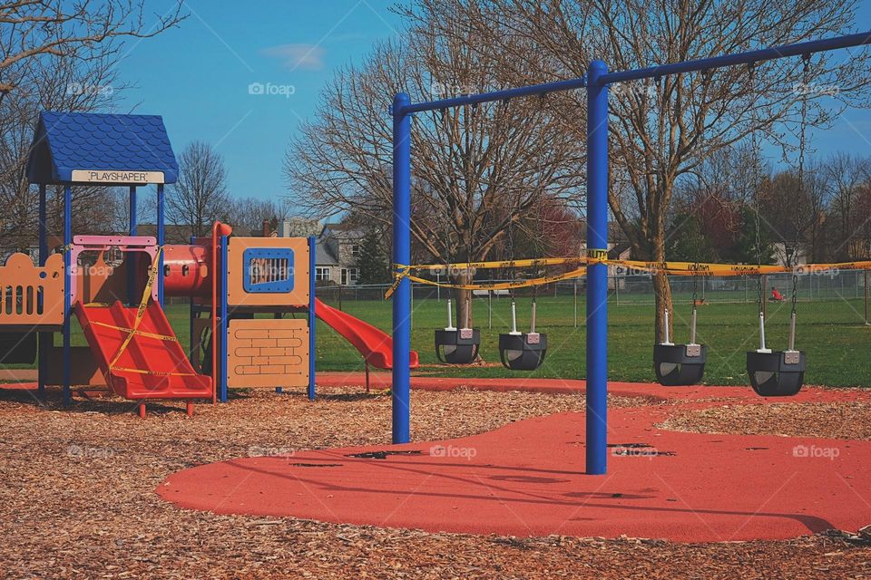 Playground during Covid, playground roped off with caution tape, Covid prevents children from playing, Covid prevents kids from having fun, caution tape at playground, sad view of a playground at a park 