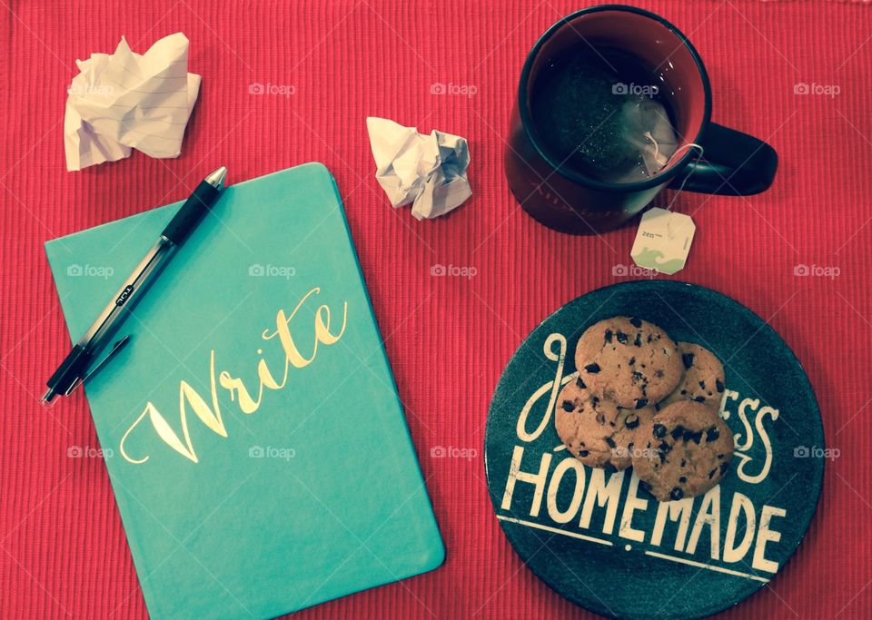 Notebook for writing with a pen on top by a mug with tea and homemade cookies 
