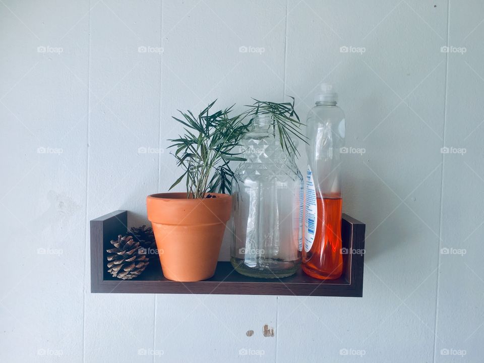 Minimal but functional shelf with vintage, chic seasonal decor and kitchen cleaning products 