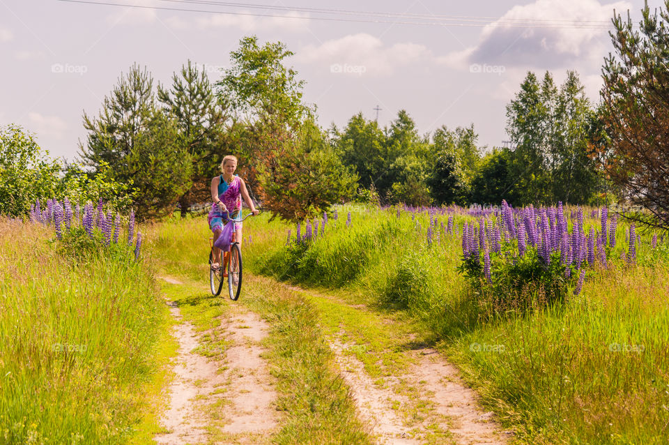 A girl is riding a bike in the summer Blooming countryside