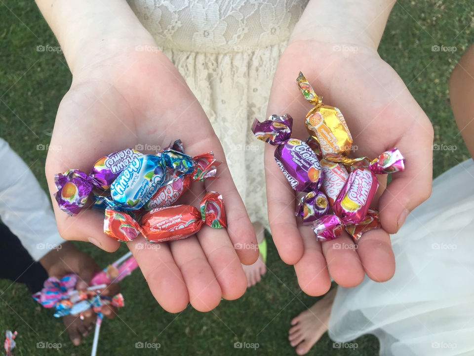 Hands full of sweets during a party with a pinyata
