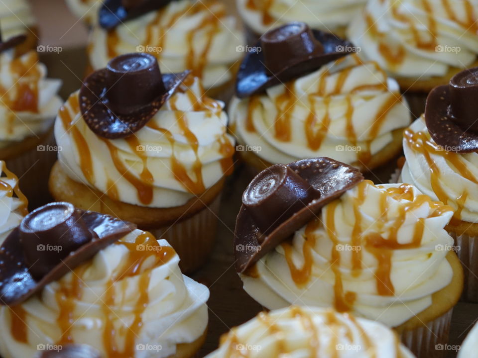 Caramel coated cupcakes with chocolate cowboy hats for decoration. 