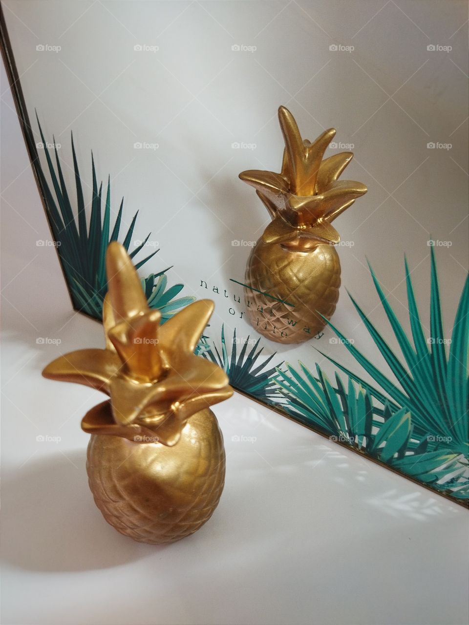 Double exposition in mirror of gold  artificial ananas .