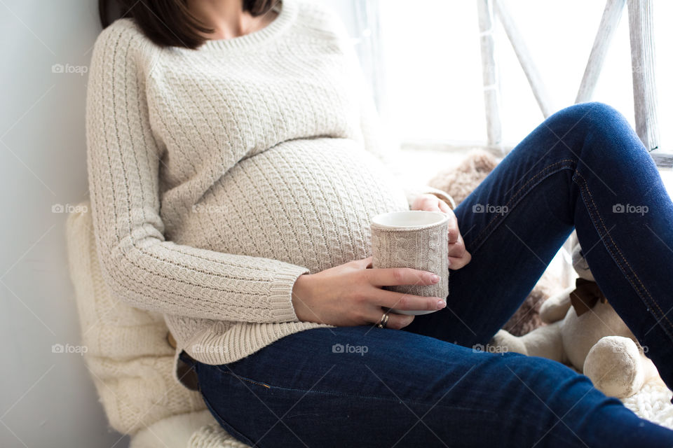 Pregnant woman holding coffee cup