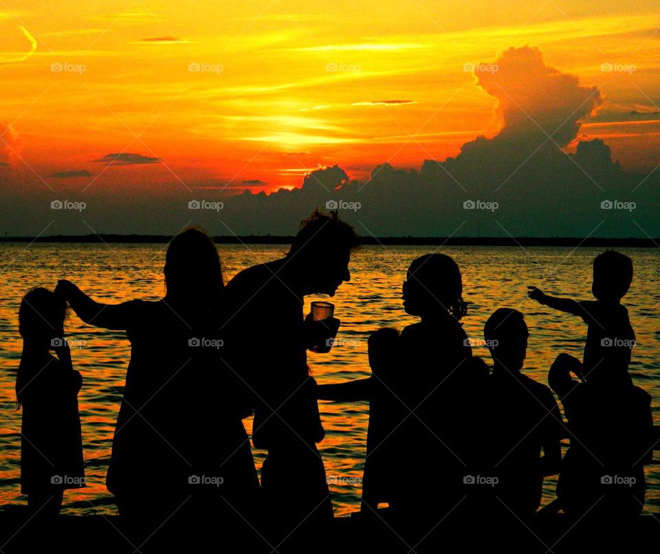 Sunset - A family gathering at the sandy beach during a descending and spectacular sunset 