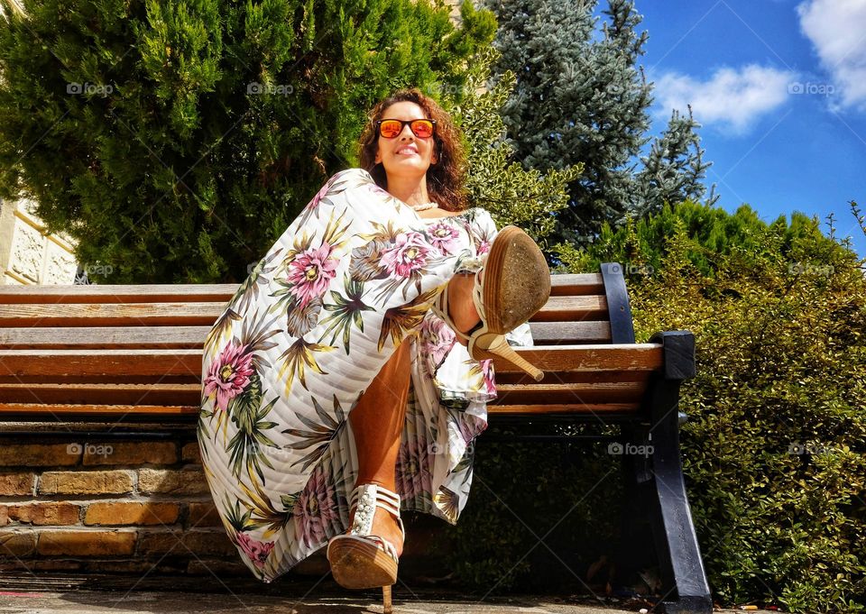 smiling woman with sunglasses photographed from below