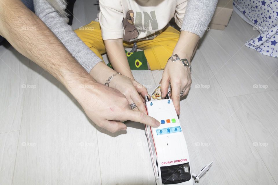 A small child with mom and dad enthusiastically and carelessly looking at gifts.