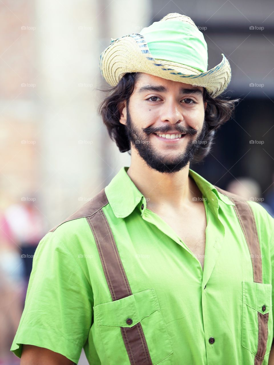 Bearded man in a green shirt and farmer hat 
