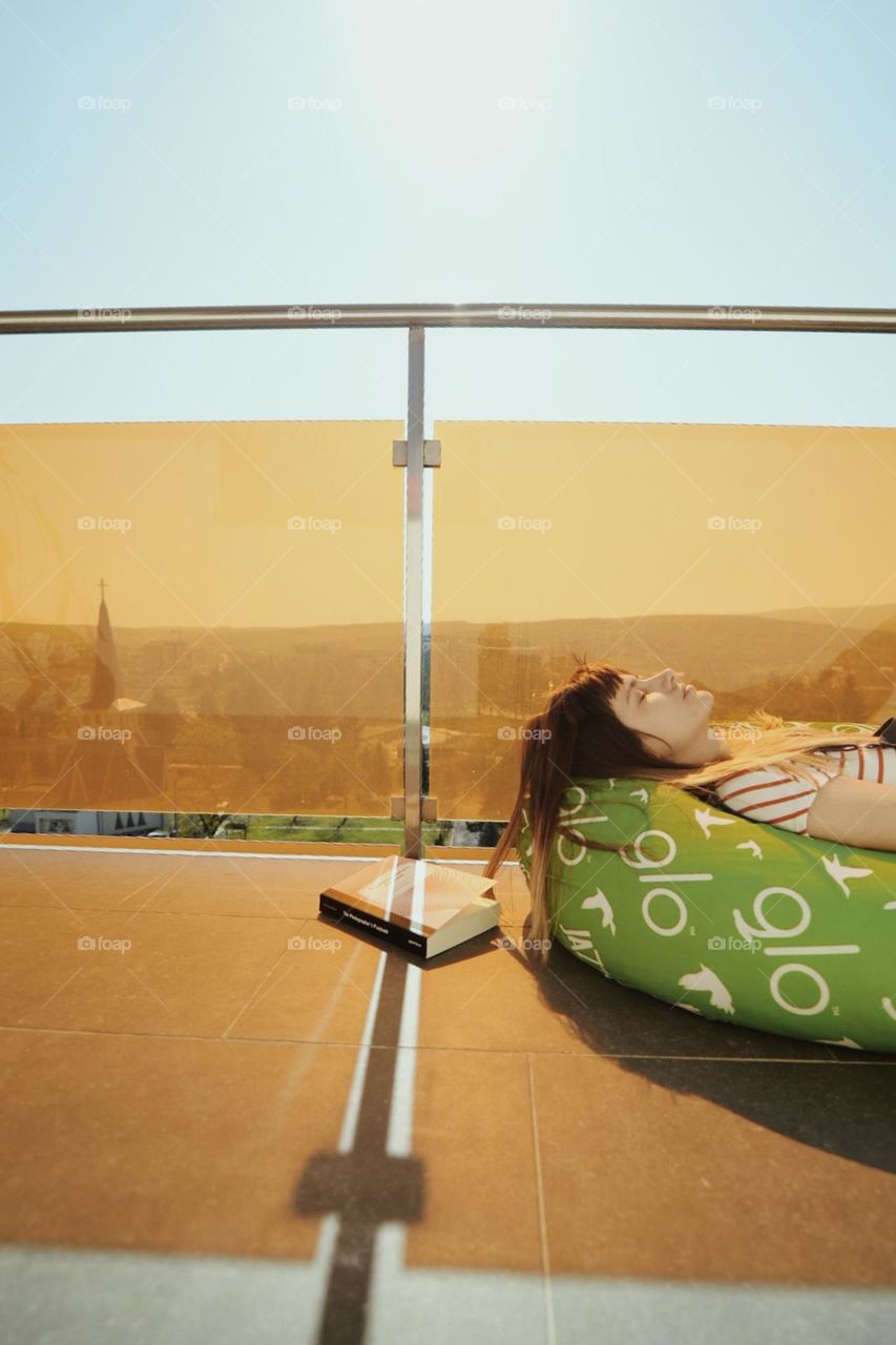 Girl relaxing in a bean bag on the balcony