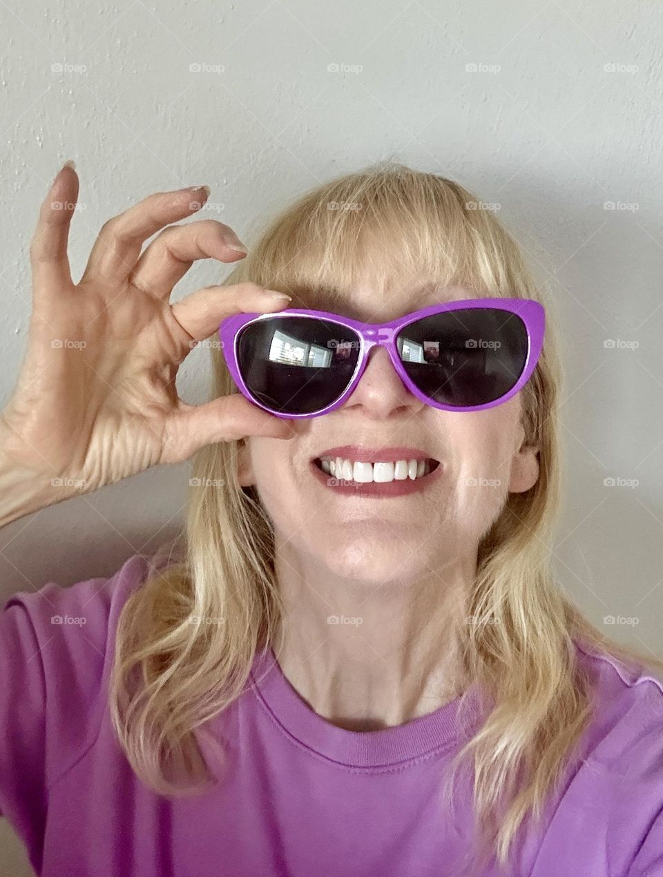 Smiling woman holding sunglasses 