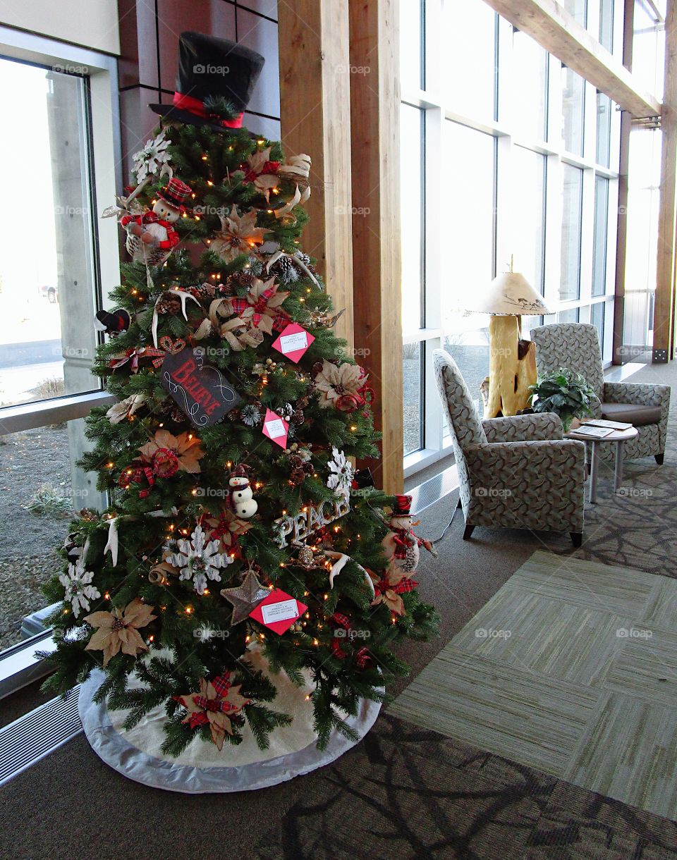 A beautiful Christmas tree decorates a lobby. 