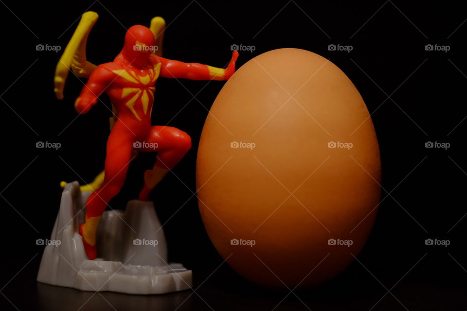 Spider-Man with an egg, Spider-Man holding an egg, funny Spider-Man pose, superheroes in the kitchen, playing with food