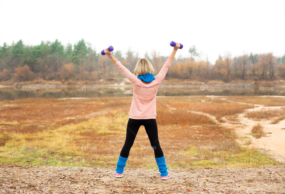 Rear view of women holding dumbbell