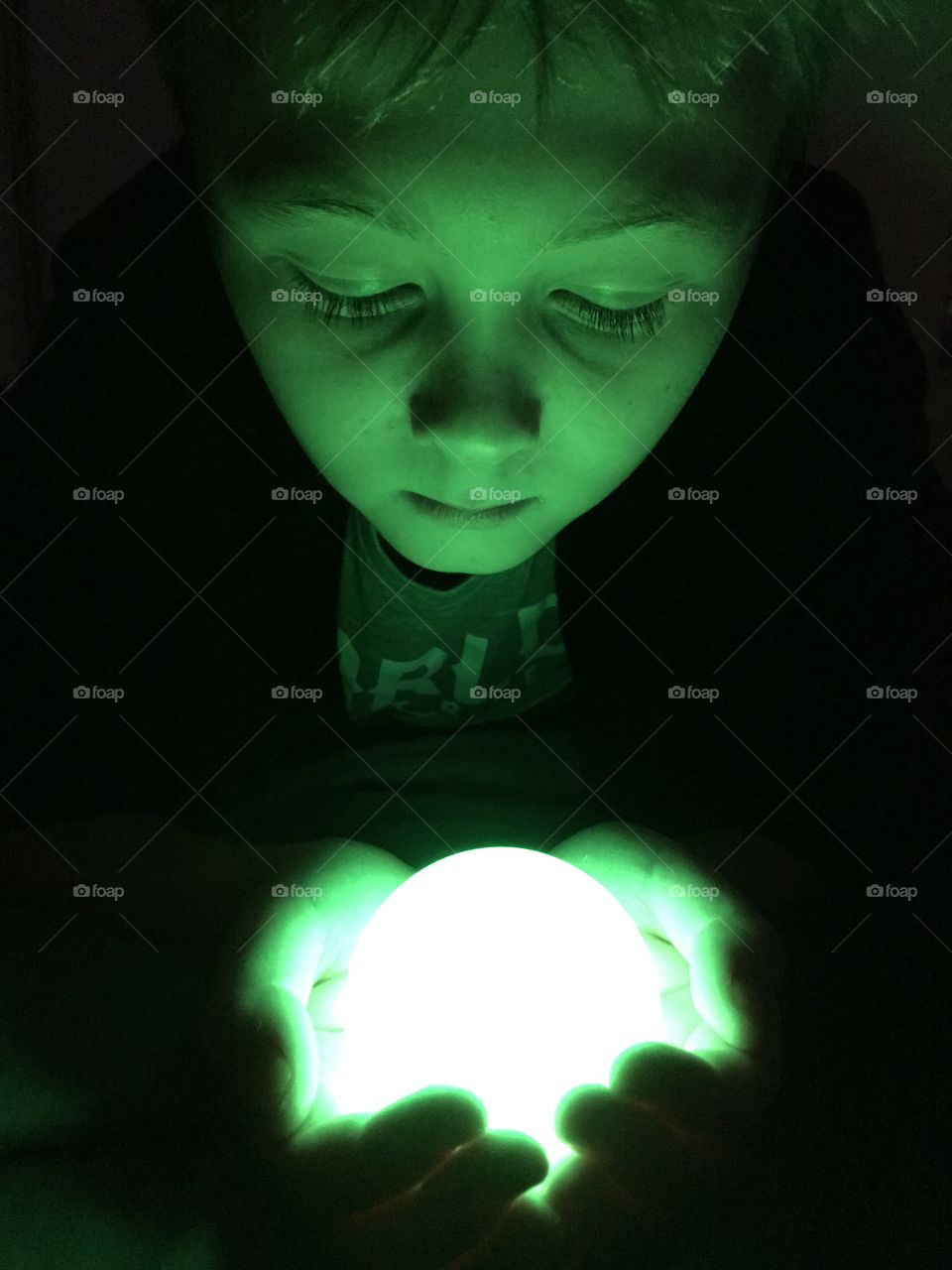 Boy looking at green glow ball
