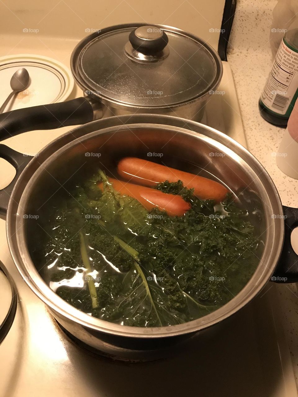 Cooked sausages and green kale at home.
