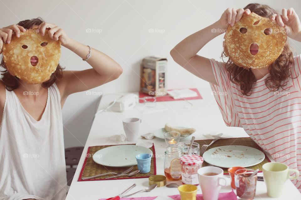 Two girl holding pancake masks