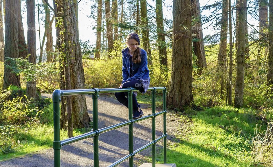 Girl sitting in forested park 