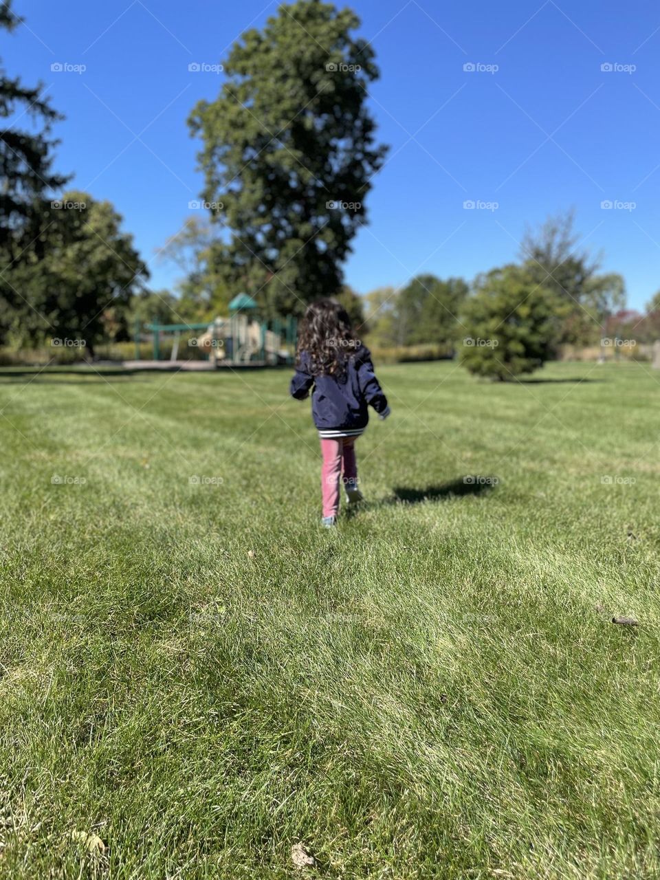 Child running in the park, toddler runs towards playground, out in the open, enjoying the outdoors, fall time in the Midwest, enjoying the playground in October 