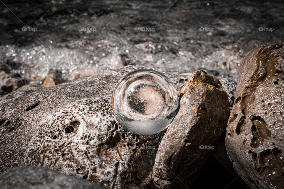 cristal ball at the rocks by the sea