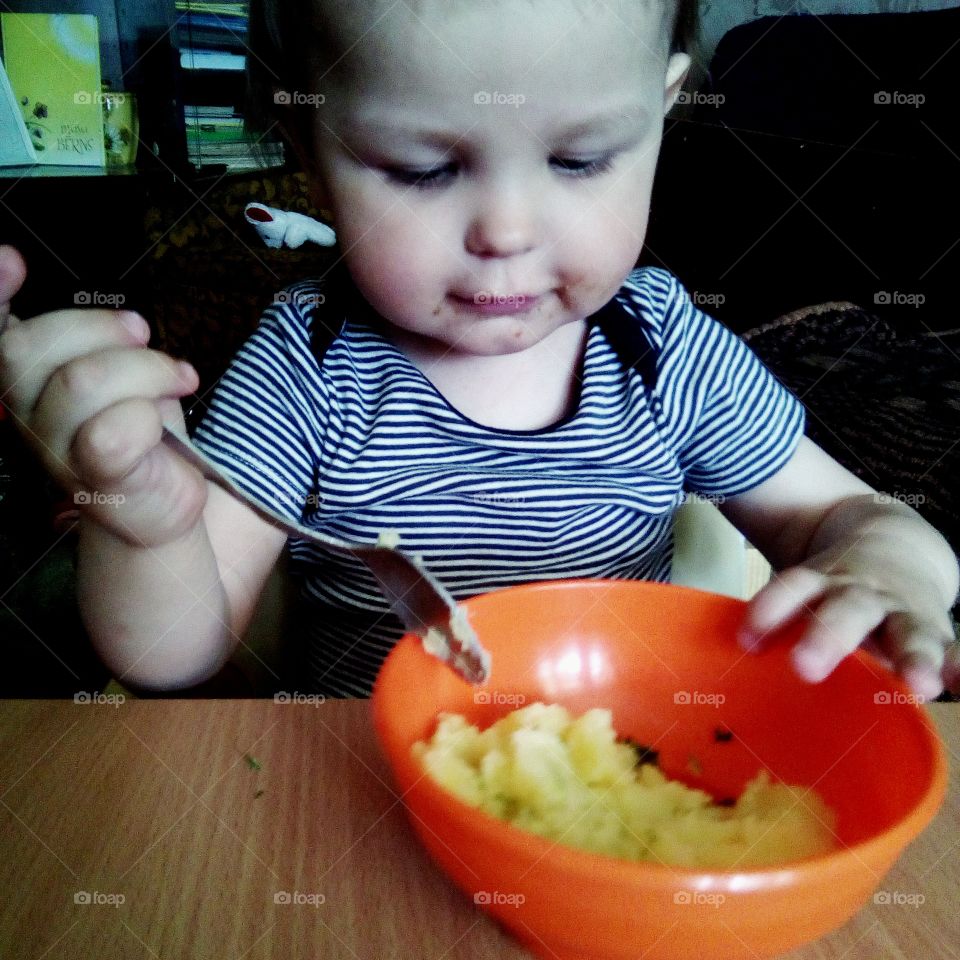 baby eating dinner on his own